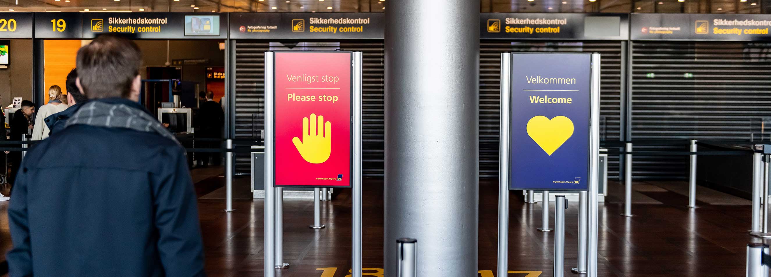 zwei Infobildschirme montiert an Gurtpfosten am Flughafen